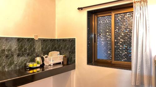 een badkamer met een raam en een zwart aanrecht bij Honeydew Suites and Villas by Goaround Homes in Vagator