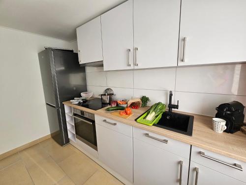 a kitchen with white cabinets and a black refrigerator at Rheinhessenglück 