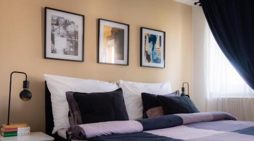 een slaapkamer met een bed met vier foto's aan de muur bij Cozy studio apartment in New Town with Disney+ in Praag