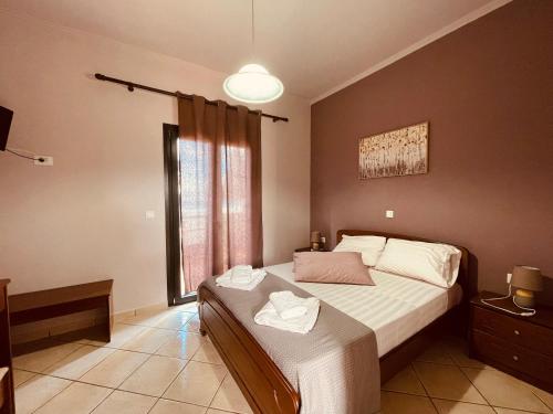 a bedroom with a bed and a large window at Girogiali Apts in Kissamos