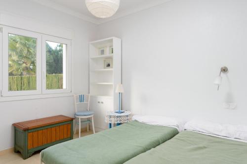 a bedroom with two beds and a table and a window at Caddy by ON Travel in Casas Devesa