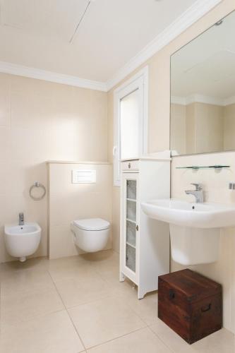 a white bathroom with a sink and a toilet at Caddy by ON Travel in Oliva