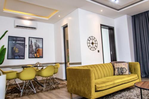 un soggiorno con divano giallo e tavolo di Treasurablehomes a Lagos