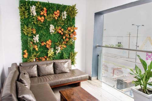 ein Wohnzimmer mit einem Sofa und einer Blumenwand in der Unterkunft Treasurablehomes in Lagos