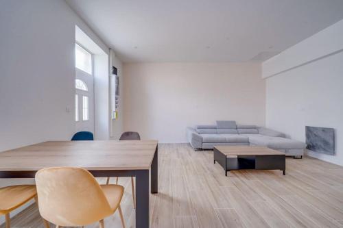 a living room with a table and a couch at Les merveilles de la palmyre in Saint-Ciers-sur-Gironde