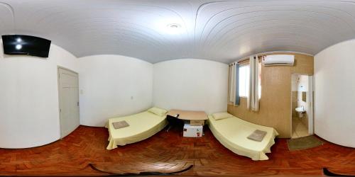 um quarto com duas camas e uma mesa em CENTRALHE HOTEL em Marília