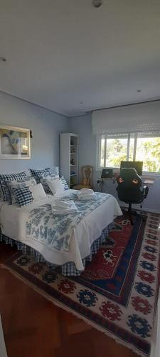 a bedroom with a large bed and a desk at Corazón do Val da Louriña-Área Vigo in Pontevedra