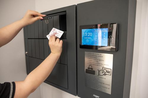 a person putting a ticket into a vending machine at Apartamenty Albatros in Augustów
