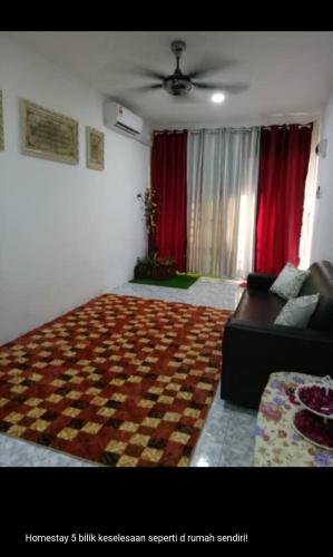sala de estar con sofá y cortinas rojas en Langkawi homestay en Pantai Cenang