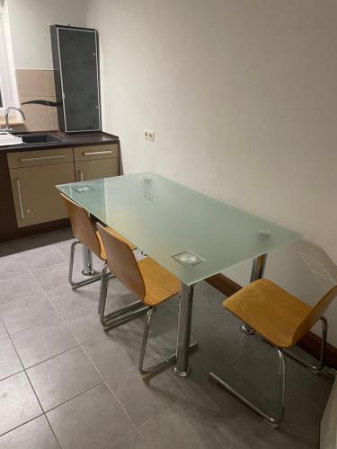 een glazen tafel met 2 stoelen in een keuken bij Zimmer in Wohnung mit Balkon in Gelnhausen