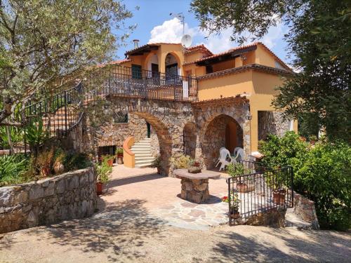 a large house with a stone building with a patio at Capocanto Rooms in Camerota