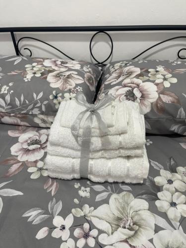 a white purse sitting on a bed with flowers at La Casuzza del Borgo in Agrigento