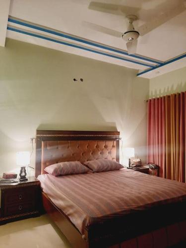 a bedroom with a large bed with two lamps on tables at A Exclusive Homes 2 Bed in DHA, Karachi in Karachi