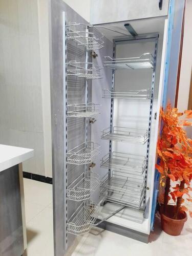 an empty refrigerator with empty shelves in a kitchen at Exclusive Homes 2 Bed in DHA, Karachi in Karachi