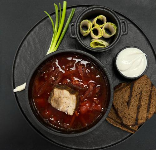 a plate of food with a bowl of soup and bread at GirskiDelux in Bukovel