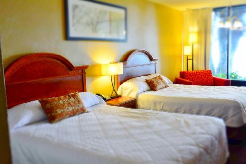 um quarto de hotel com duas camas e uma cadeira em Crystal Cove Riverfront Resort em Palatka