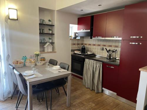 a kitchen with red cabinets and a table with chairs at Petite maison in Fiumicino