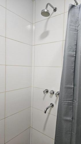 a shower with two faucets and a shower curtain at Departamento Vista Malargüe in Malargüe