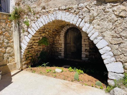 a stone tunnel with a door in a stone wall at Guesthouse near the Castle of Himare in Himare