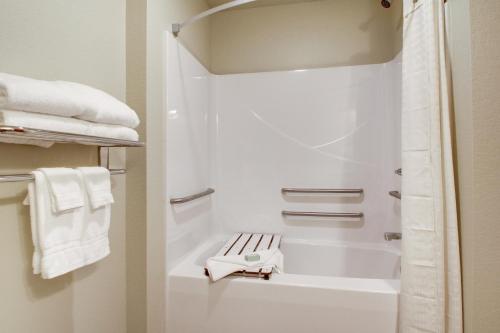 a bathroom with a shower with white towels at Cobblestone Hotel & Suites - Salem in Salem