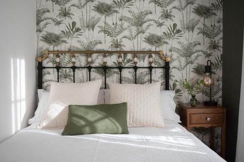 1 dormitorio con cama blanca y papel pintado con motivos florales en Casa Tarrío con Piscina - Santiago de Compostela en Boqueijón