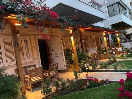 a house with a bench and flowers in the yard at Guest Room Angolo Toscano in Vlorë