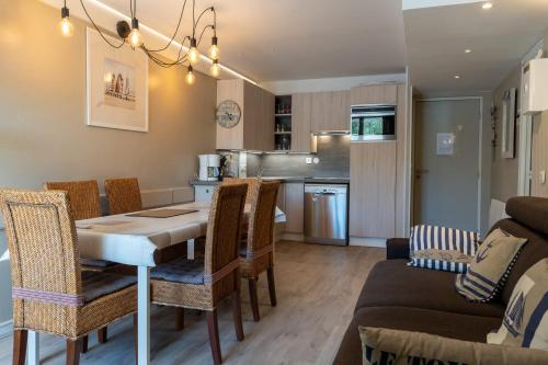 une cuisine et un salon avec une table et des chaises dans l'établissement Beautiful flat with swimming pool tennis court and private car parking 264, à Le Touquet-Paris-Plage