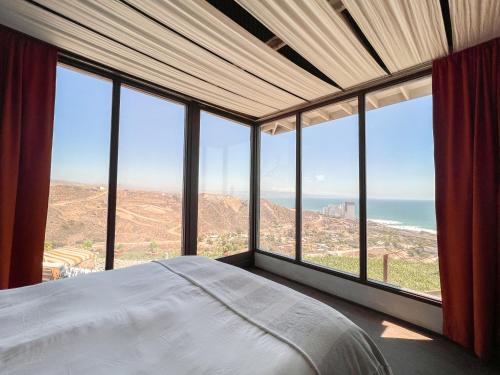 a bedroom with a bed with a view of the ocean at Native Residence in Rosarito