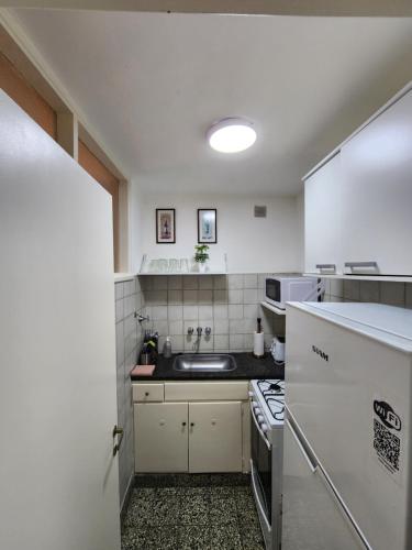 uma pequena cozinha com um lavatório e um fogão em Departamento en Edificio Maral 14, Colon, zona Guemes. em Mar del Plata