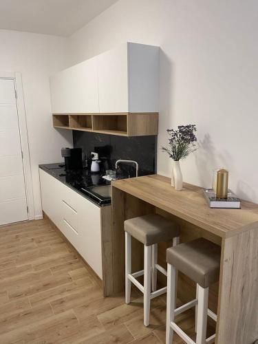 a kitchen with a wooden counter with stools in it at Apartmani Vidikovac in Prijepolje