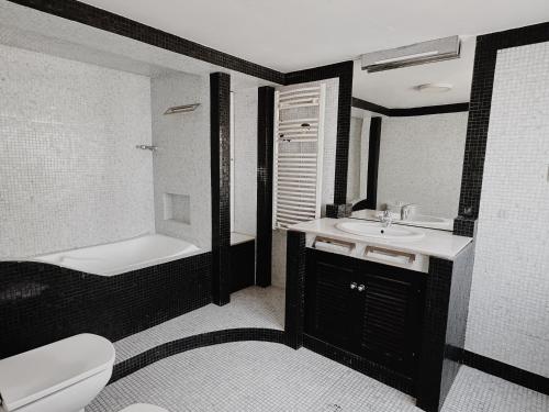 a bathroom with a toilet and a tub and a sink at Soar Home in Lisbon