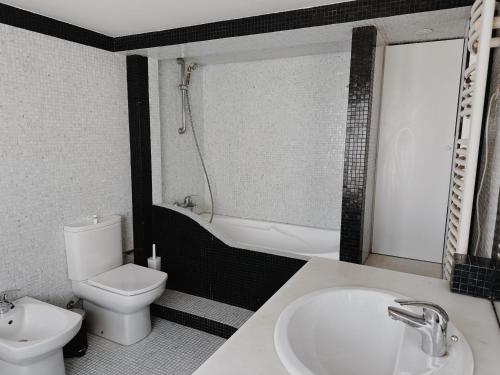 a bathroom with a sink and a toilet and a bath tub at Soar Home in Lisbon
