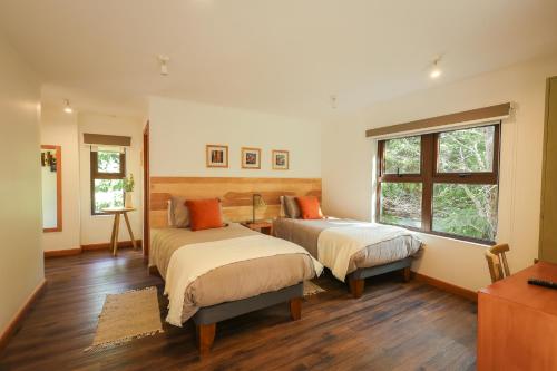 a bedroom with two beds and a window at PURA Hotel in Coihaique