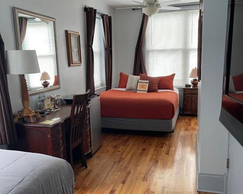 a bedroom with a bed and a desk and two windows at Ray's Bucktown Bed and Breakfast in Chicago