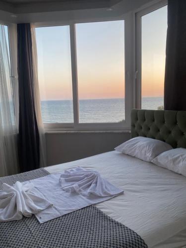 a bedroom with a bed with a view of the ocean at Adil Butik Otel in Didim