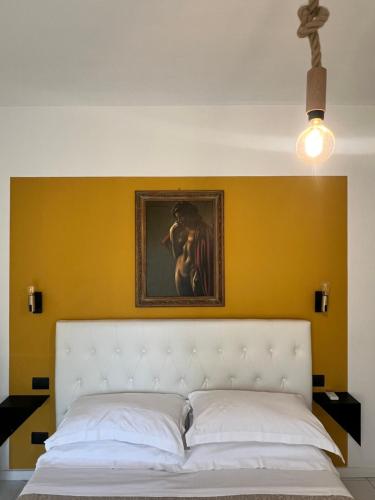 a bedroom with a bed with a painting on the wall at 5 Viale Fano Apartment in Rimini