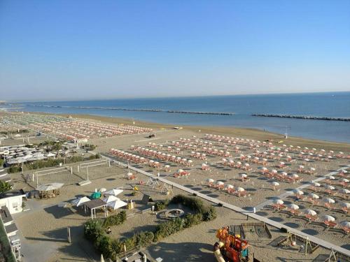 una spiaggia piena di ombrelloni e l'oceano di Hotel ROSE NUOVE a Rimini