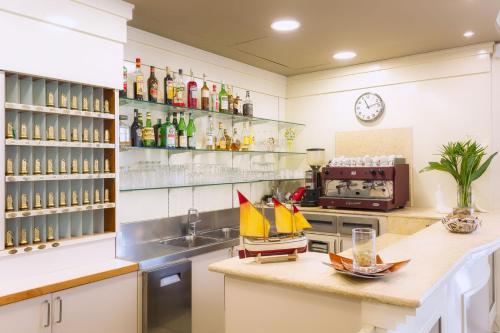 una cocina con fregadero y una barra con un barco. en Hotel ROSE NUOVE, en Rímini