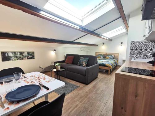 ein Wohnzimmer mit einem Sofa und einem Tisch in der Unterkunft Le Tropical l Calme l Clim l Parking gratuit in Istres