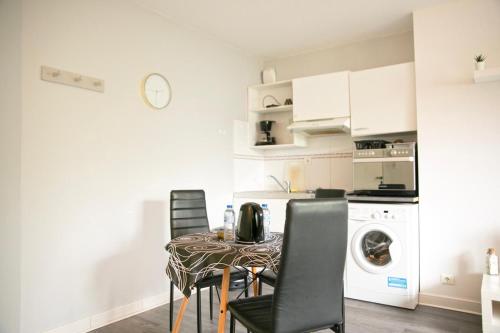 a kitchen with a table and chairs and a kitchen with a washing machine at Orphee Superbe T2 calme et paisible in Nantes