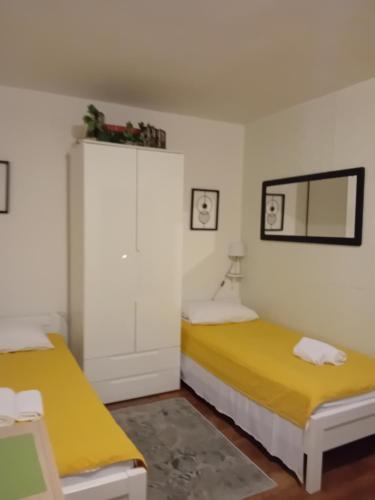 - 2 lits dans une chambre avec des draps jaunes dans l'établissement Studio Sofia 2, à Novalja