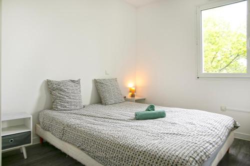 a bed in a white room with a window at Orphee Superbe T2 calme et paisible in Nantes