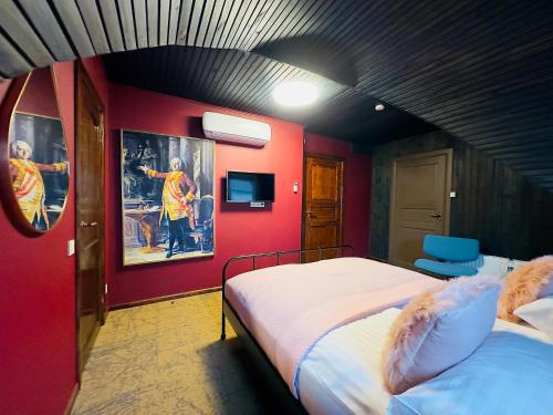 a bedroom with two beds and a red wall at Broken bed hootel in Kaunas