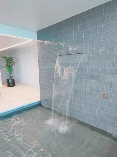 a water fountain in a blue tiled bathroom at Bayline- Beachfront and Pool in Armação de Pêra