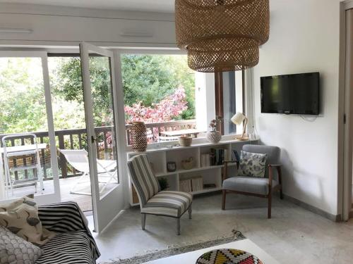 d'un salon avec un canapé et des chaises ainsi que d'un balcon. dans l'établissement Appartement calme et familial au Centre d'Hossegor, à Soorts-Hossegor