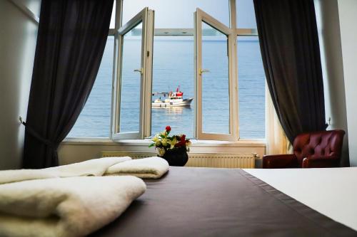 Arsin的住宿－Yıldız Moonlight Hotel Trabzon，一间卧室设有大窗户,水中设有一条船