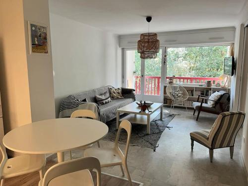 un salon avec un canapé, une table et des chaises dans l'établissement Appartement calme et familial au Centre d'Hossegor, à Soorts-Hossegor