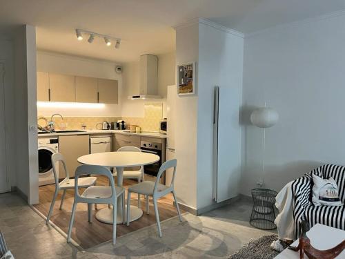 une cuisine avec une table et des chaises dans une pièce dans l'établissement Appartement calme et familial au Centre d'Hossegor, à Soorts-Hossegor