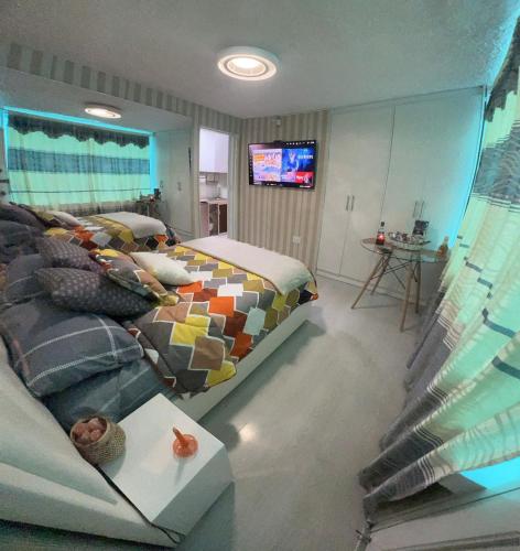 a bedroom with a bed and a couch and a television at Gold House Oro in Quito