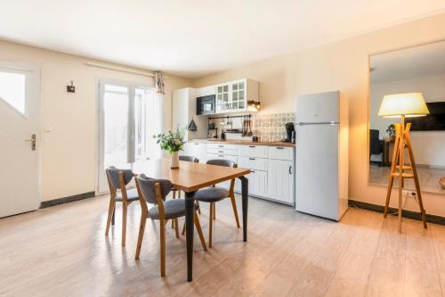 une cuisine avec une table, des chaises et un réfrigérateur dans l'établissement Les balcons de l'Hermitage, à Crozes-Hermitage